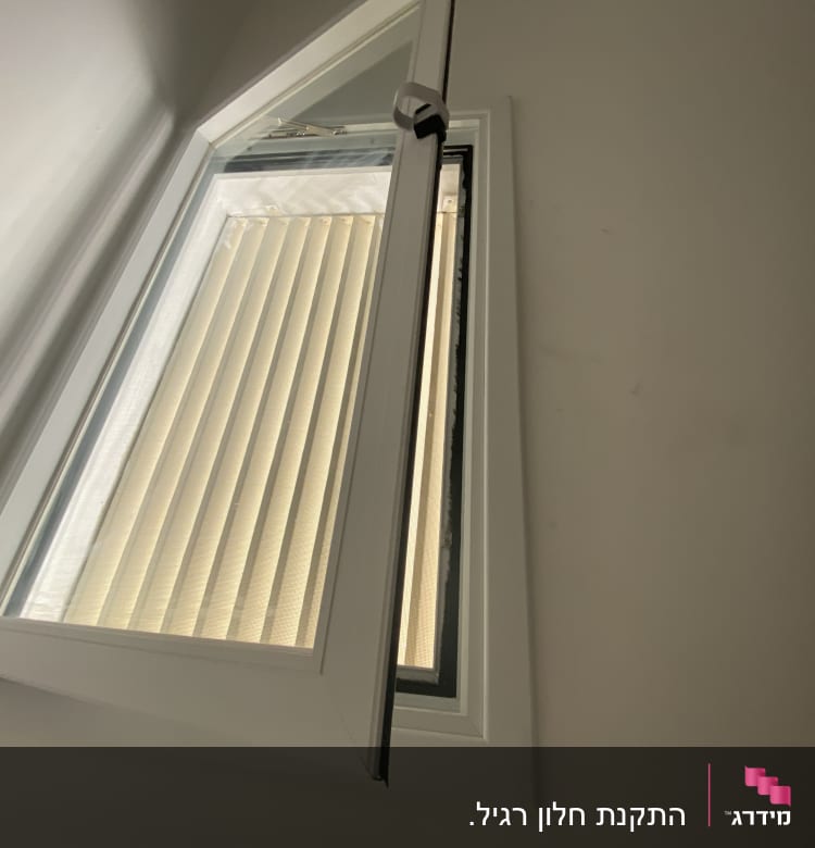 חלון אלומיניום פתוח עם מסגרת לבנה